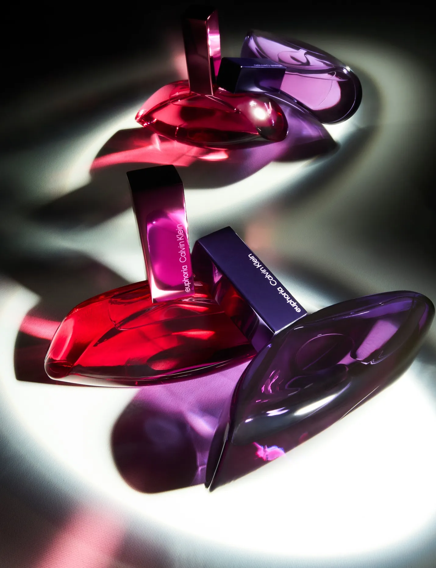 Advertising image of a two luxury CK fragrance bottle with dramatic studio lighting and reflection in background.