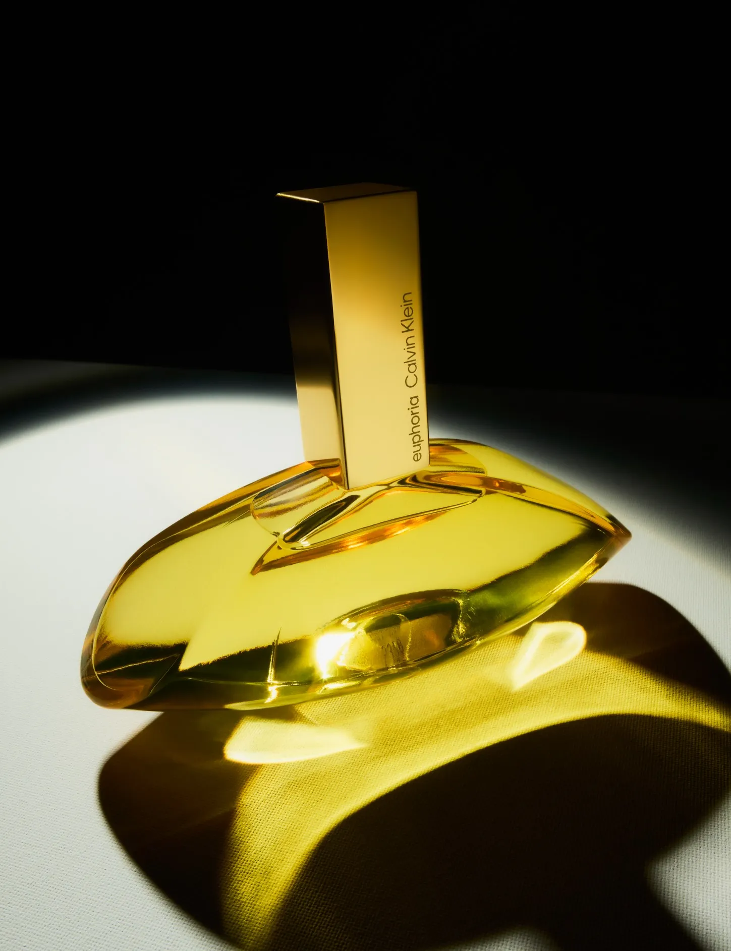 Advertising image of a luxury CK fragrance bottle with dramatic studio lighting.