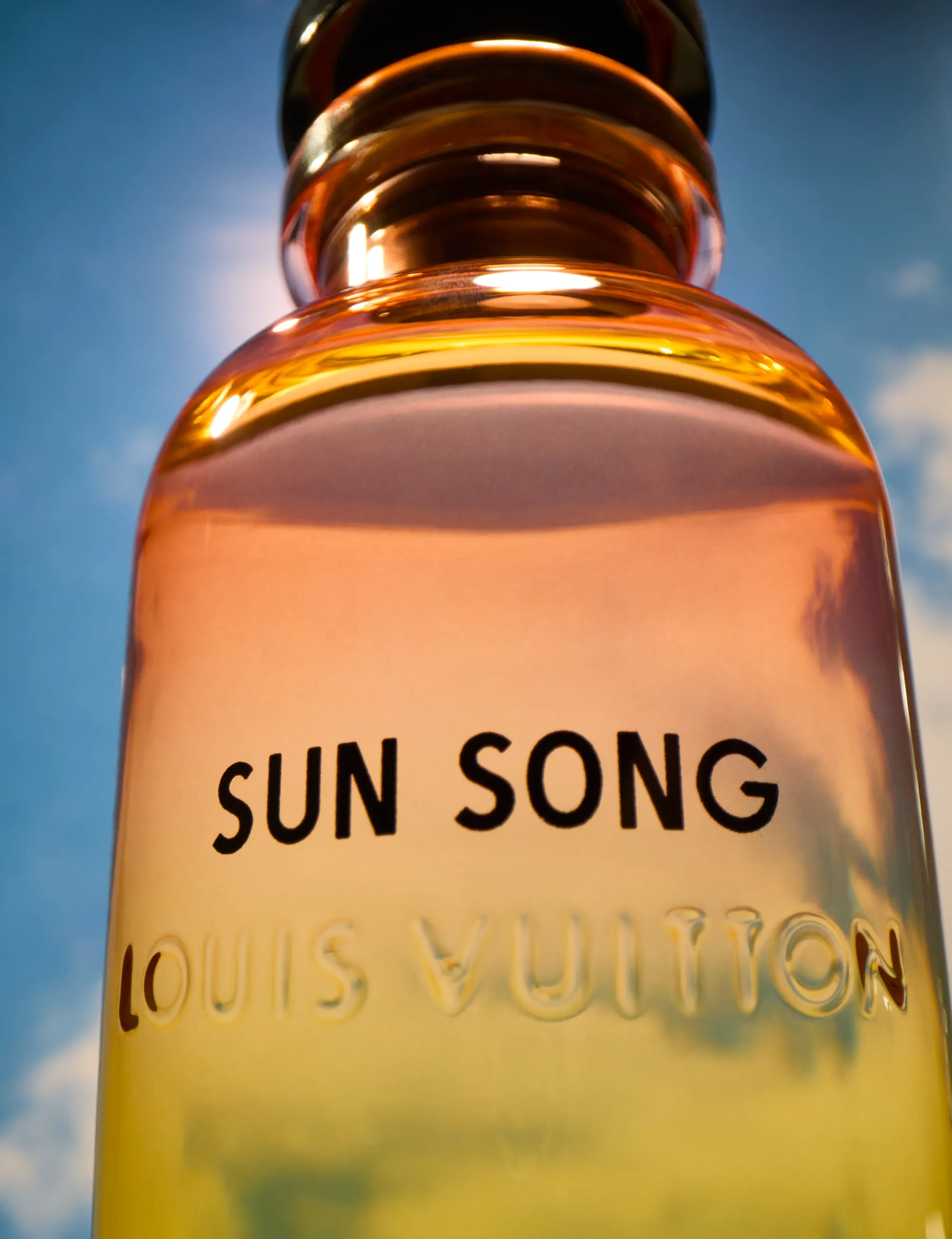still life photograph of louis vuitton sun song fragrance cropped into background of a sky in the sun