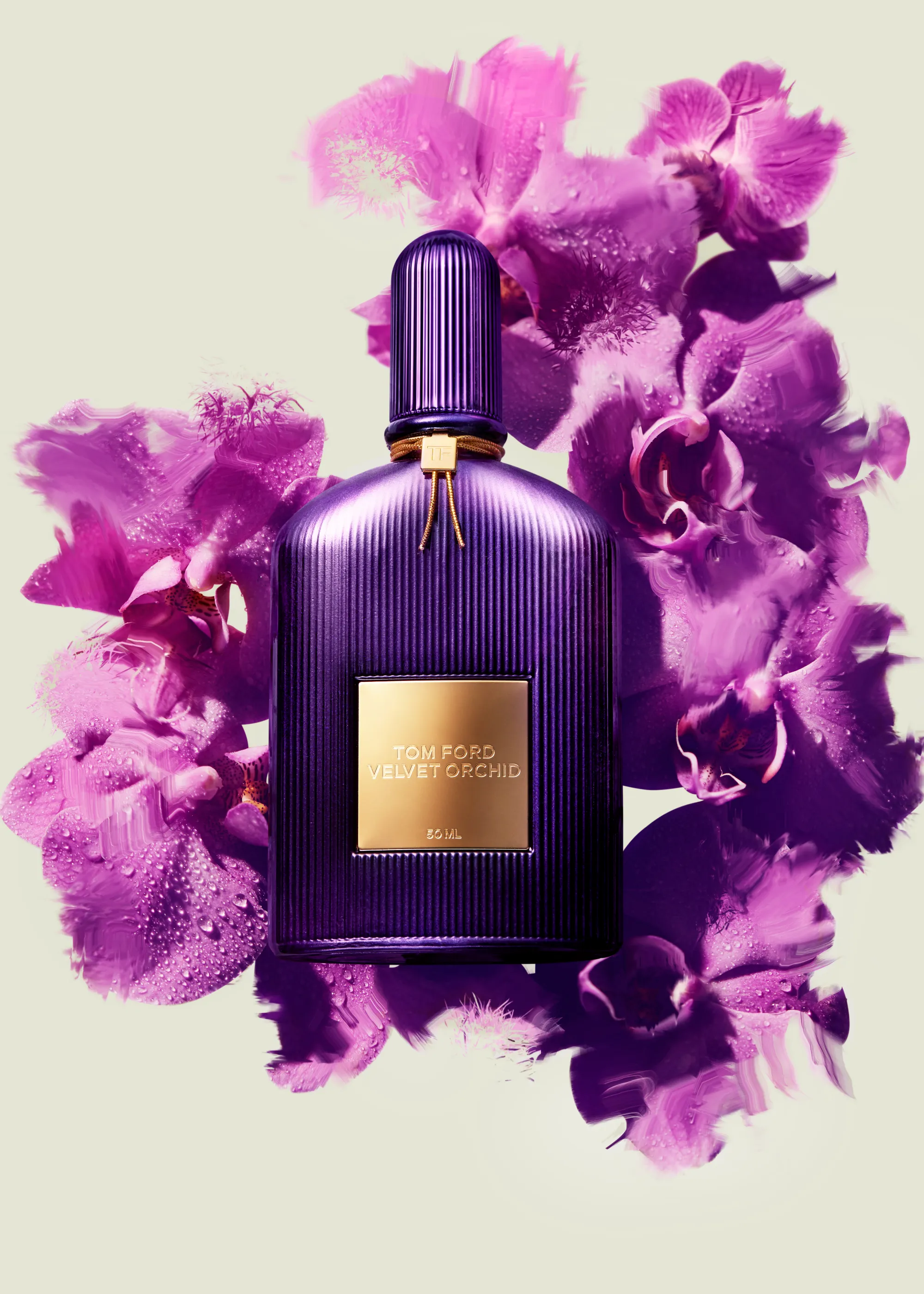 Perfume bottle photographed on top of bed of orchids with sculptural lighting and shadows.